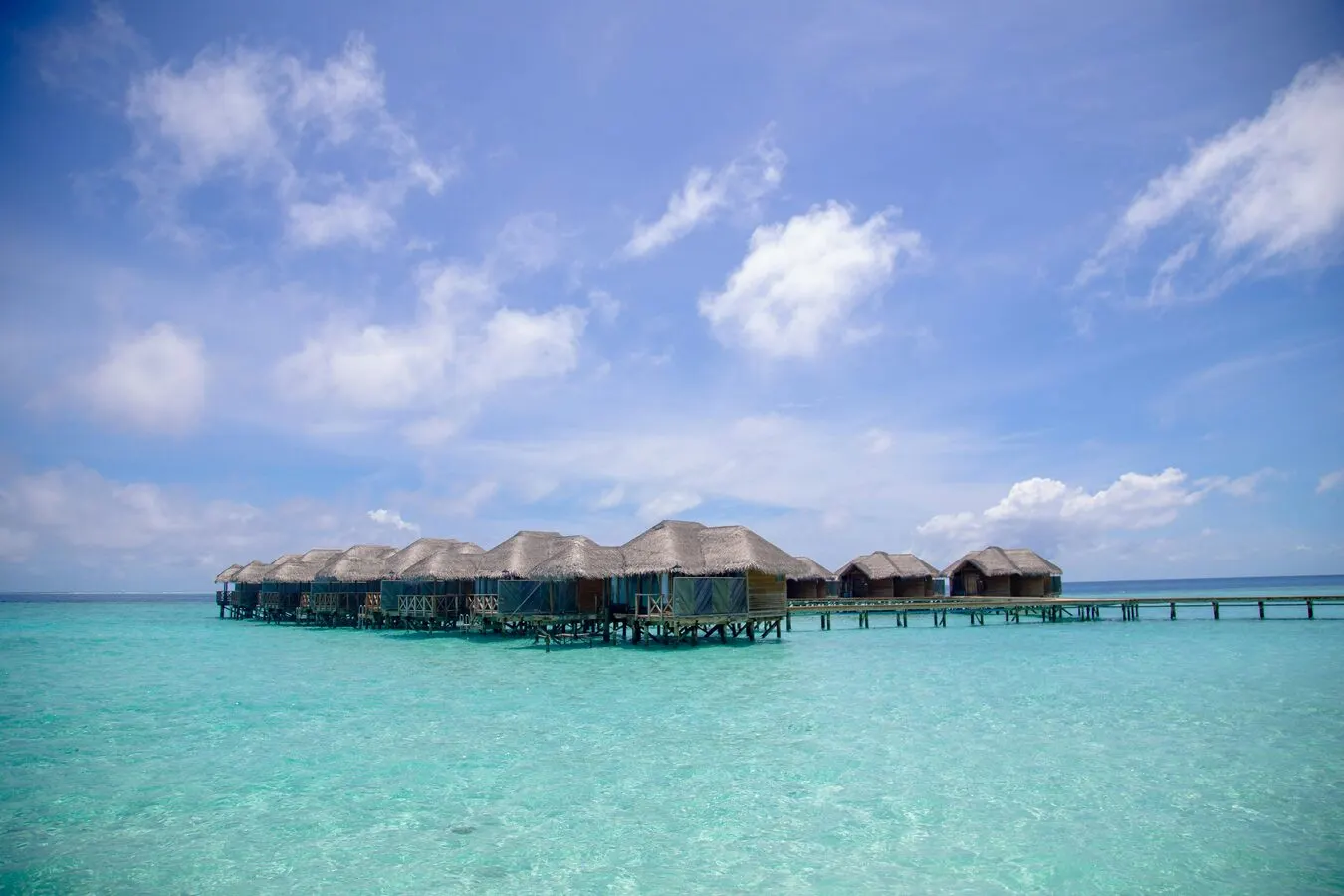 Pristine Zanzibar beach with turquoise water and overwater bungalows — bush and beach honeymoon safari